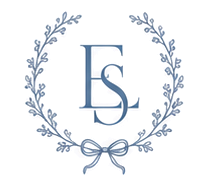 An embroidered monogram of the letters E and S inside an oval floral wreath tied with a bow
